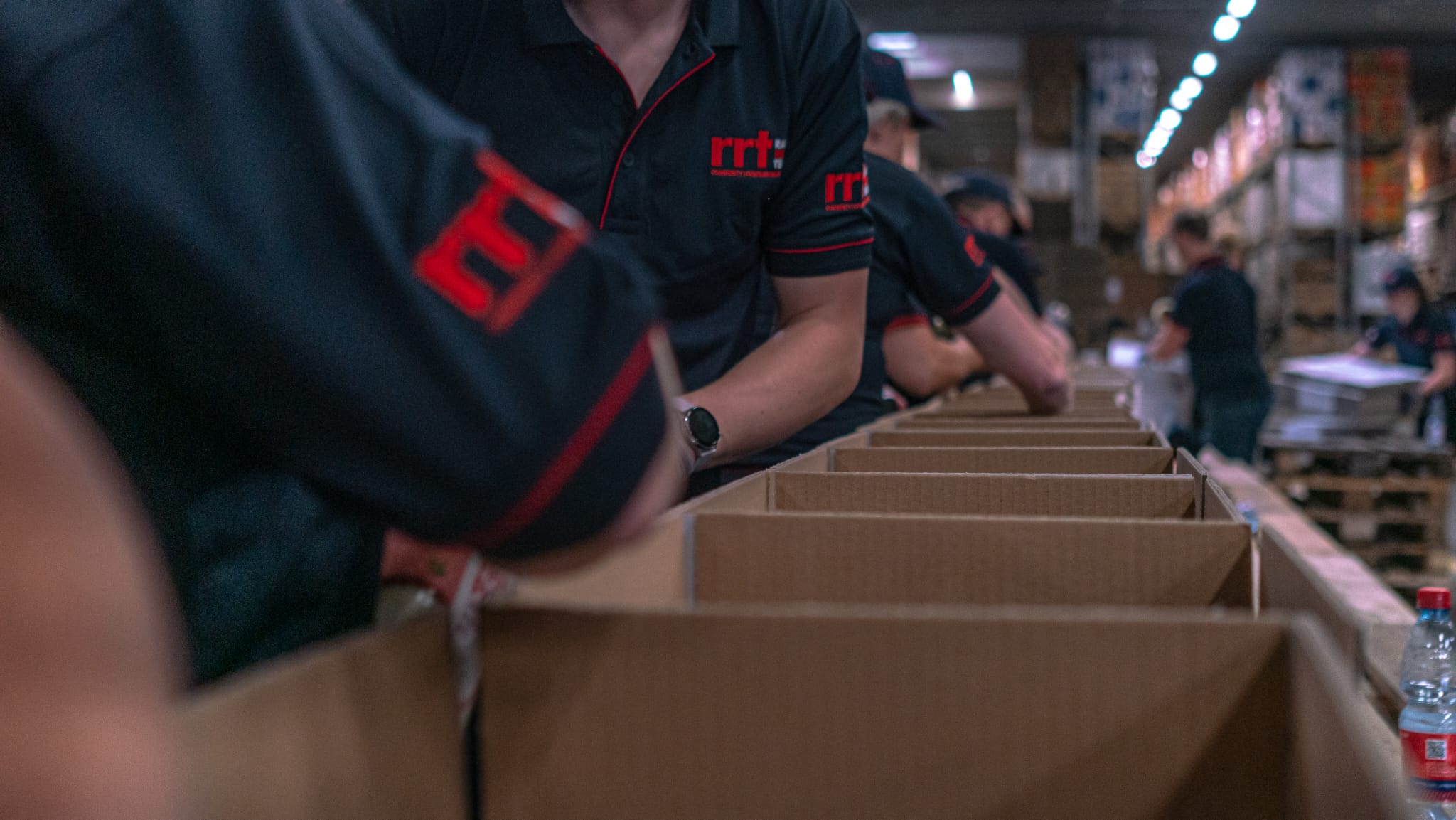 Body shot of people in uniforms packing boxes