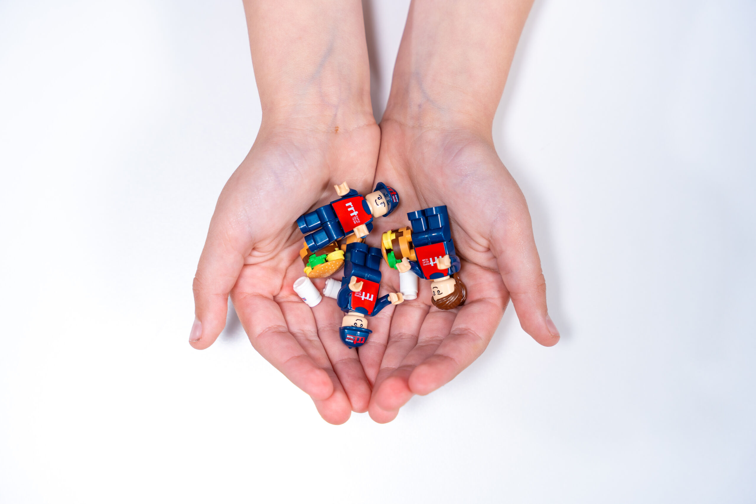 A person holding Lego fingers in RRT uniforms